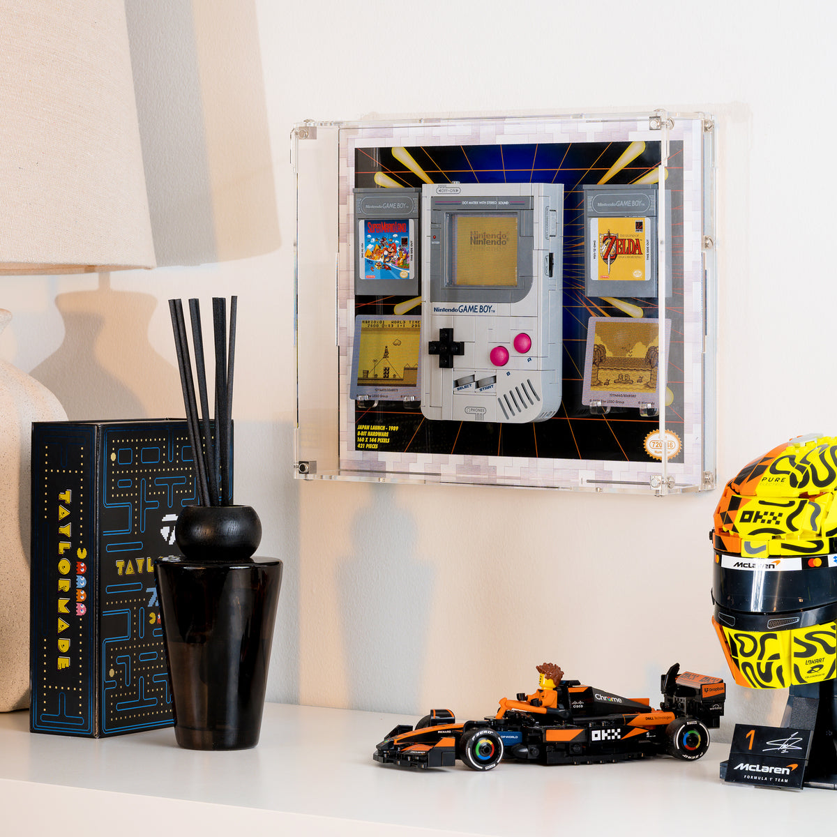 The wall-mounted Game Boy display case seen from an angle, with other LEGO models on the shelf below